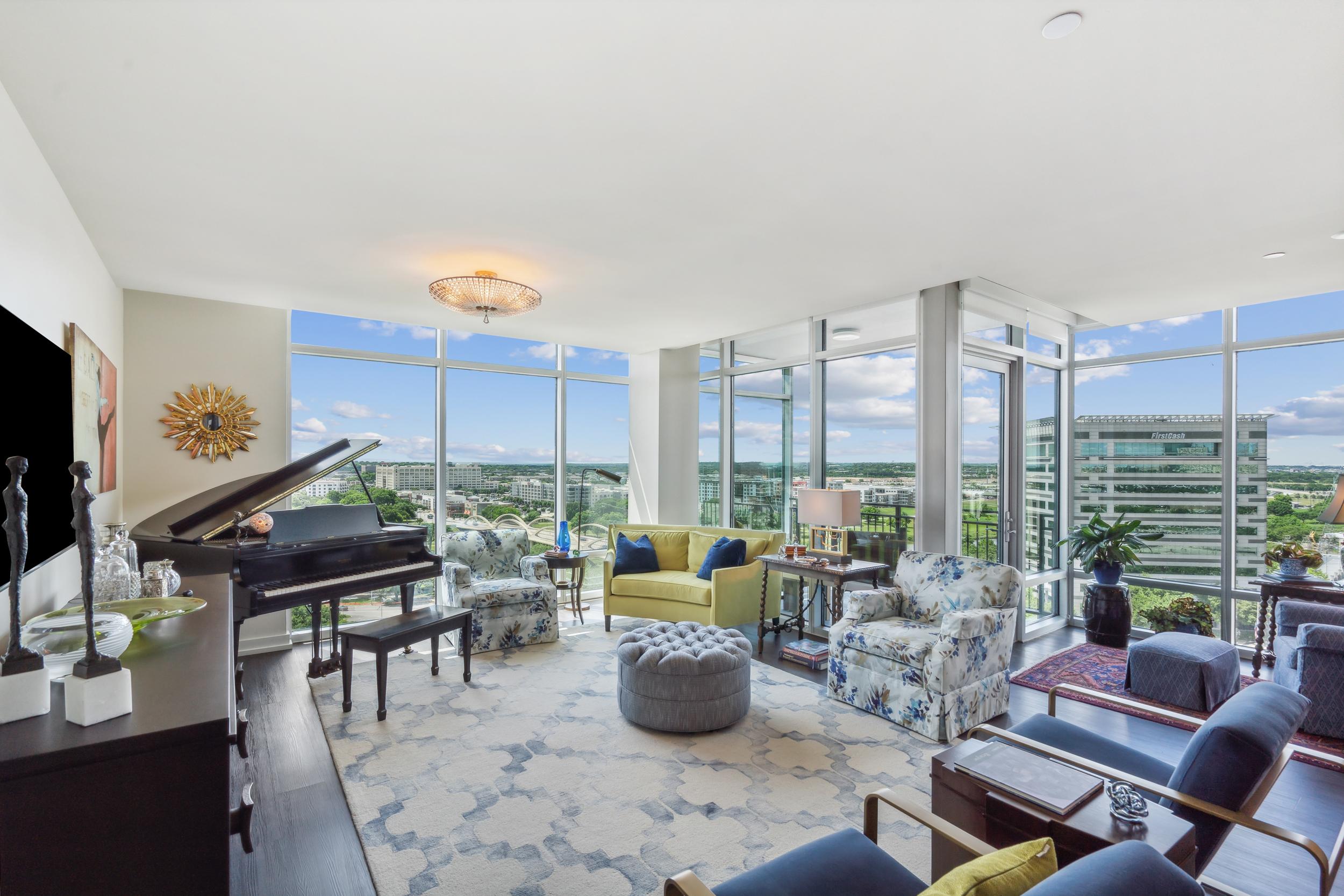 A large living room with a baby grand piano and variety of seating in the Leon floor plan.