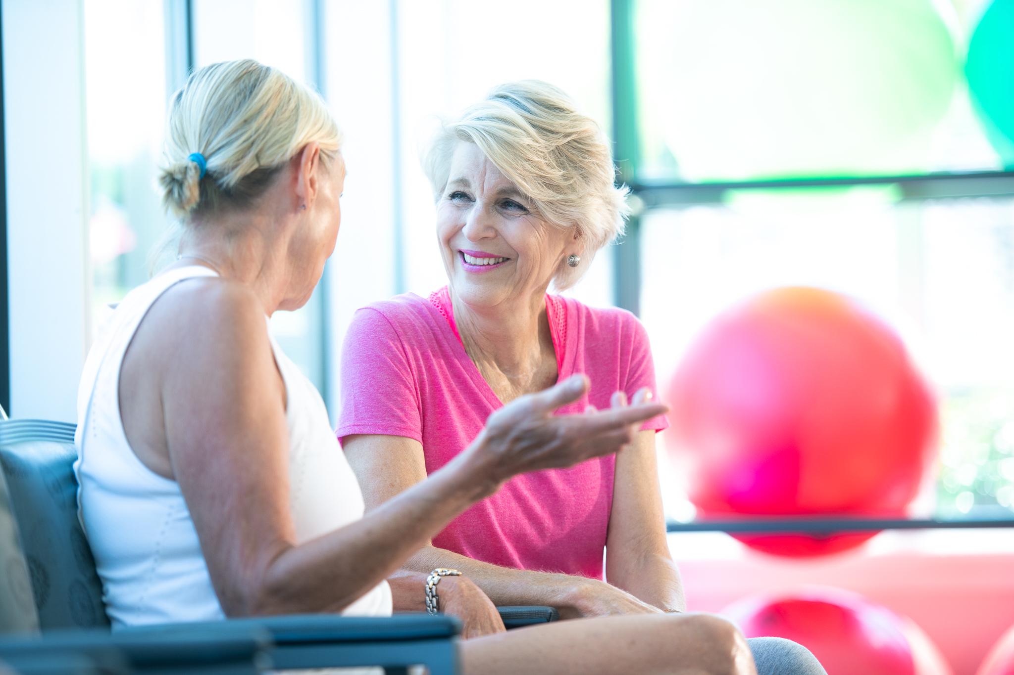 Two women smile and talk at Trinity Terrace.